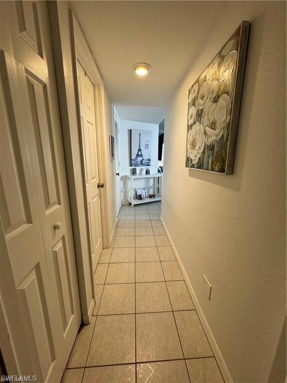Corridor with light tile patterned floors and baseboards