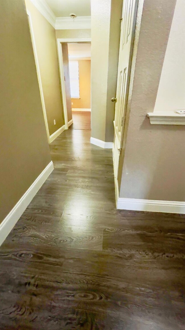 Hall featuring wood finished floors and ornamental molding