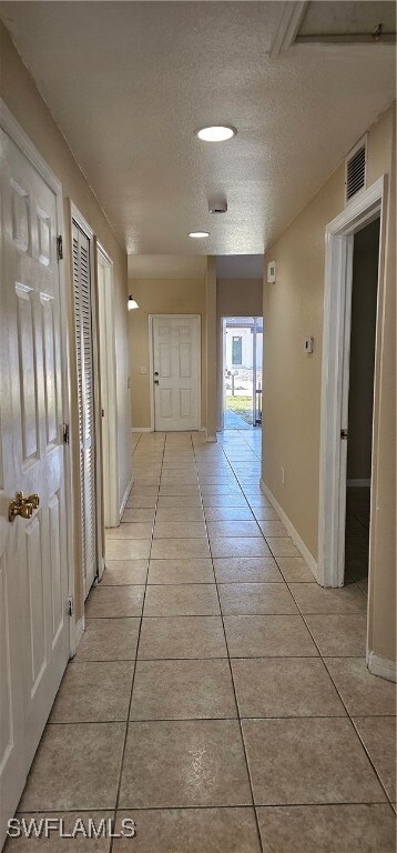 Corridor featuring light tile patterned flooring,