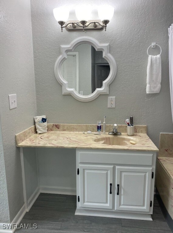 Bathroom featuring a textured wall, wood finished