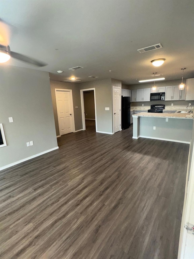 Kitchen with light countertops, baseboards, fridge