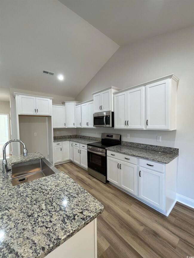 Kitchen with stainless steel appliances, vaulted c