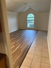 Bonus room with lofted ceiling and light tile patterned floors