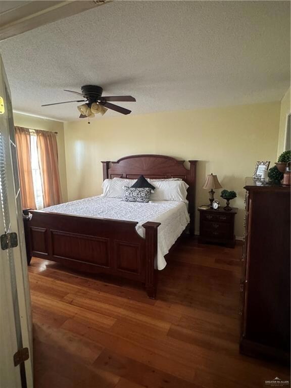 Carpeted bedroom featuring ceiling fan and a textured ceiling