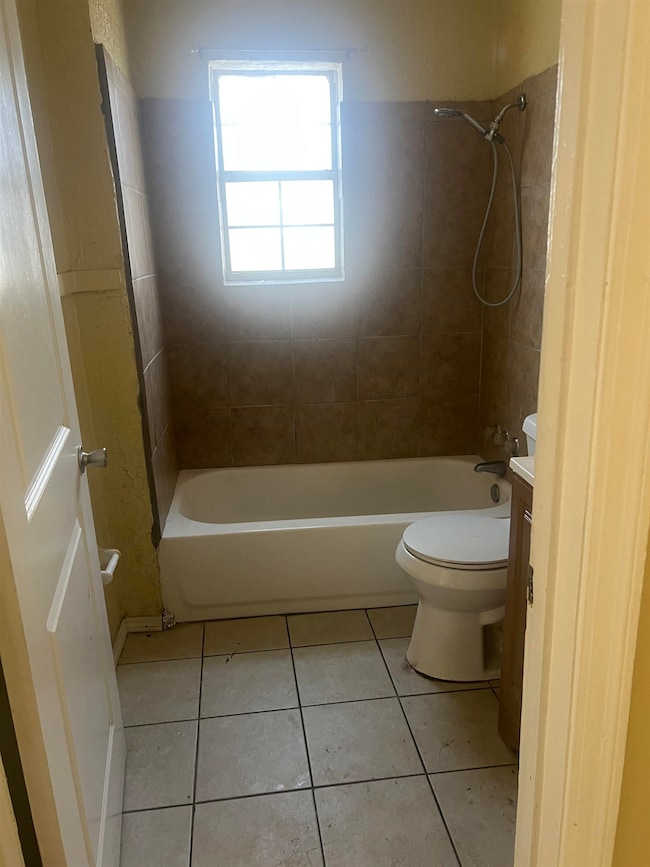Full bath with toilet, vanity, tile patterned floo