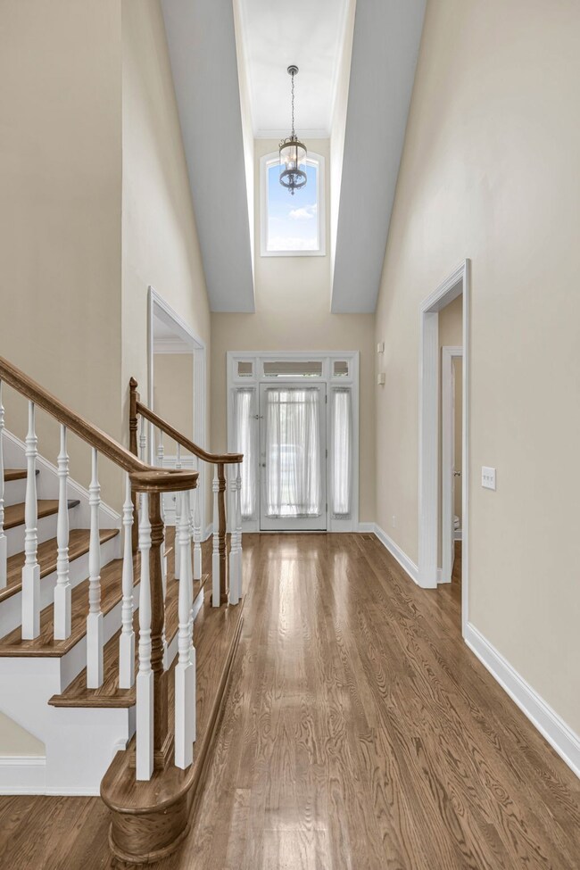 This view captures the grand entry which makes a beautiful statement with its cathedral ceiling and real sand-and-finish oak hardwood floors which carry through much of the first floor.