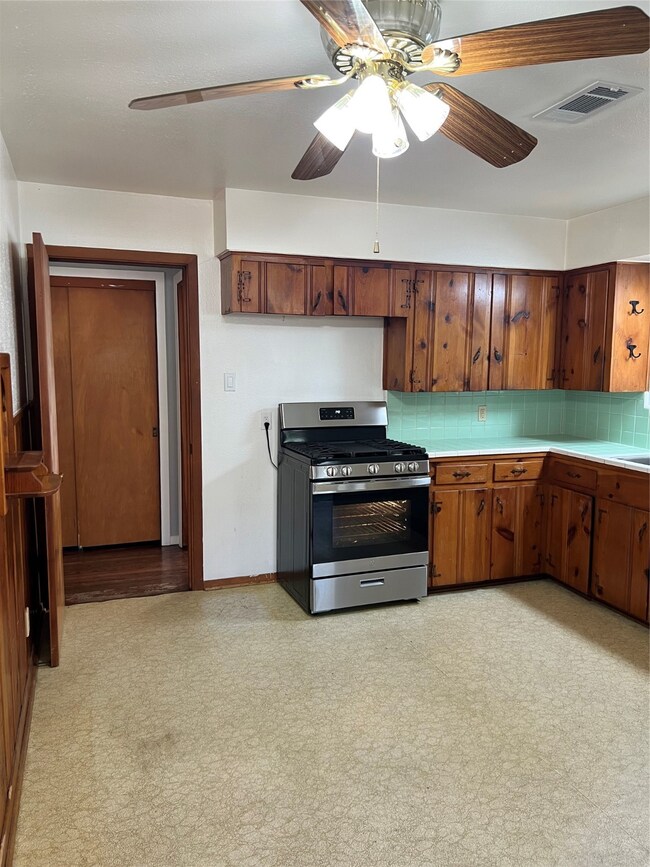 This kitchen has a cozy feel with green tile backs