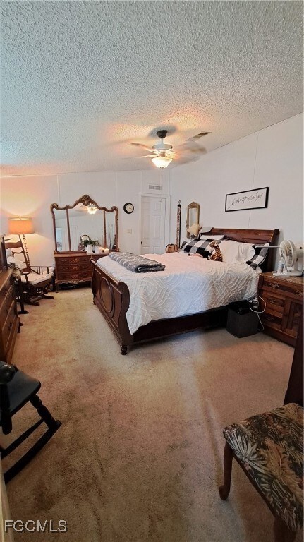 Carpeted bedroom with a textured ceiling and a ceiling fan