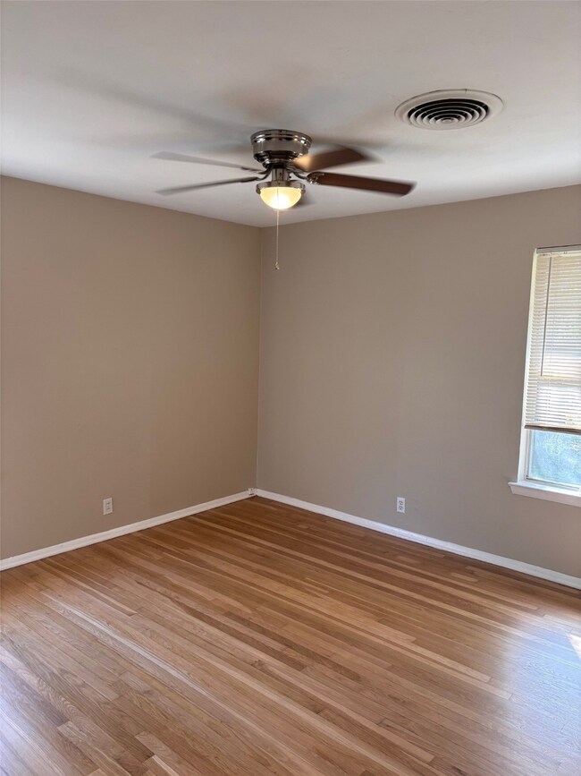 Empty room featuring light wood-style floors and a ceiling fan