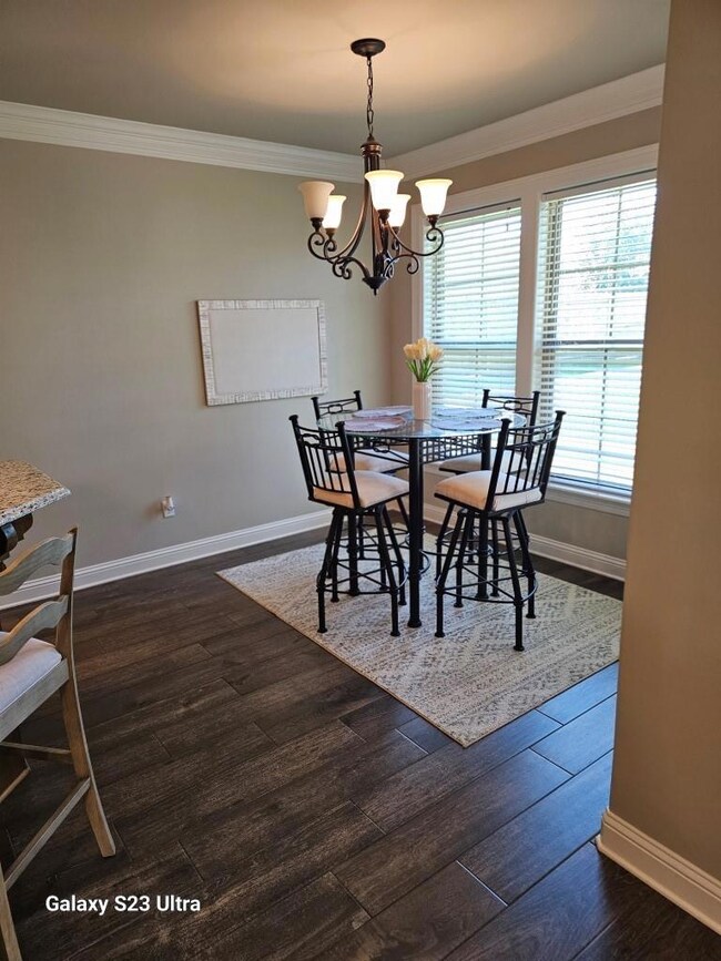 Dining space featuring crown molding, dark hardwoo