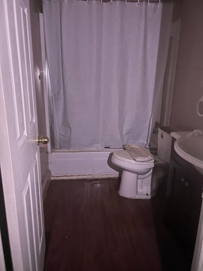 Full bath with vanity, shower / bath combo, and wood finished floors