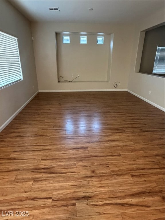 Empty room with baseboards and light wood-type flooring