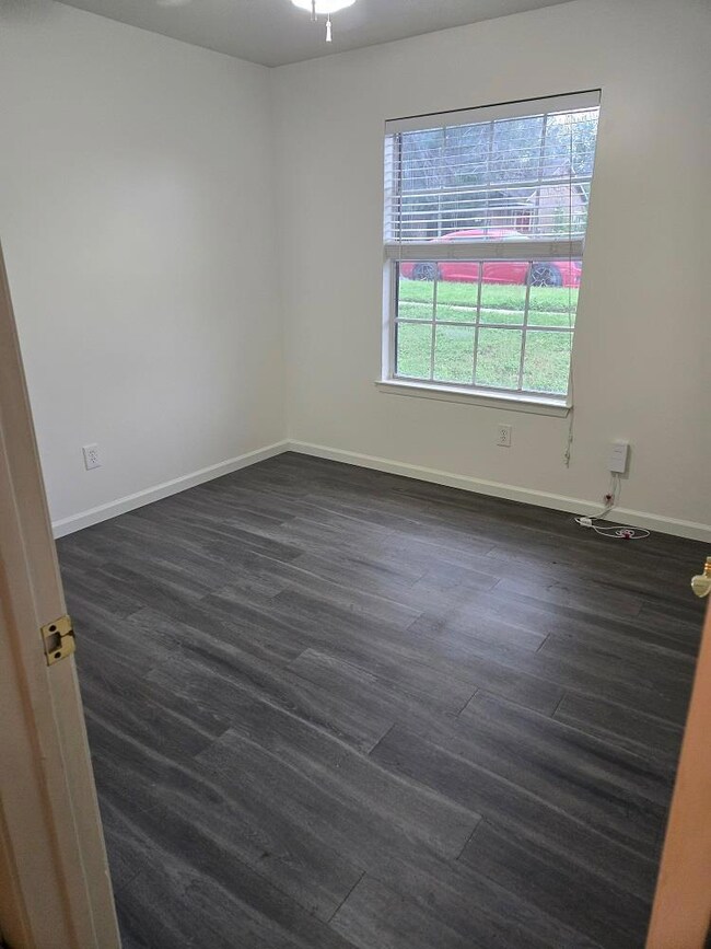 Spare room with dark wood-type flooring and baseb