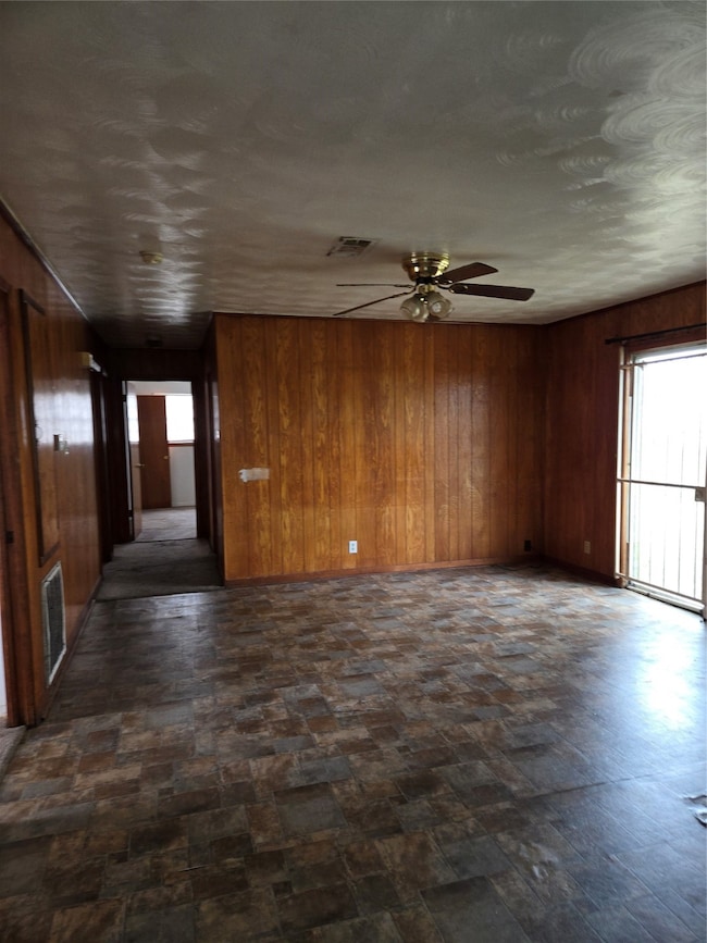 This room features wood-paneled walls, a ceiling f