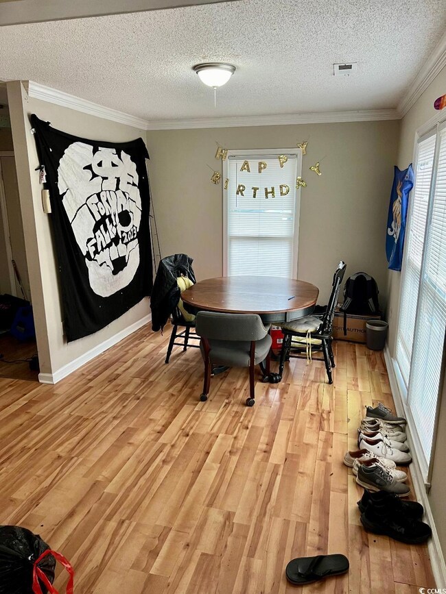 Dining room with a textured ceiling, crown molding