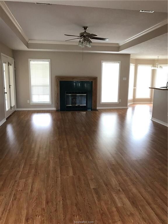 Unfurnished living room featuring baseboards, a ra