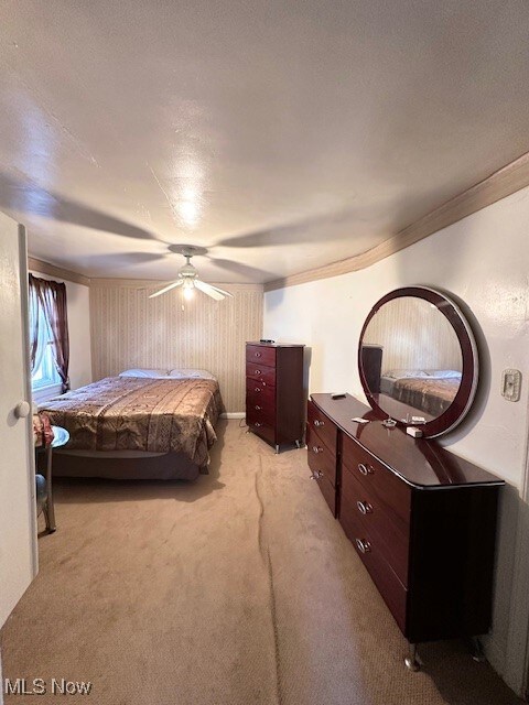 Carpeted bedroom with ceiling fan and a textured ceiling