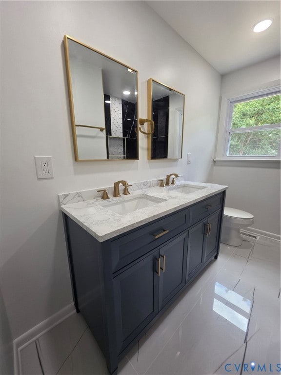 Bathroom featuring double vanity, recessed lighting, and a shower