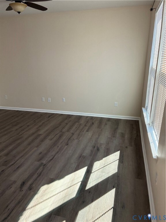 Spare room with dark wood-style flooring and a ceiling fan