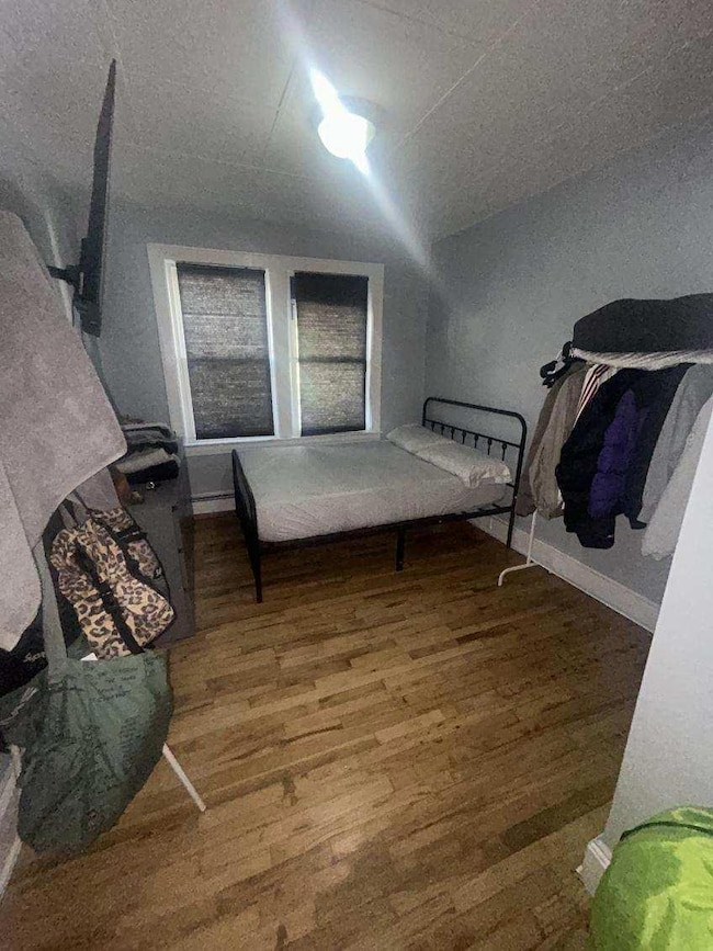 Bedroom with wood finished floors and lofted ceiling