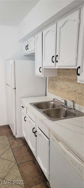 Kitchen with white dishwasher, white cabinets, bac