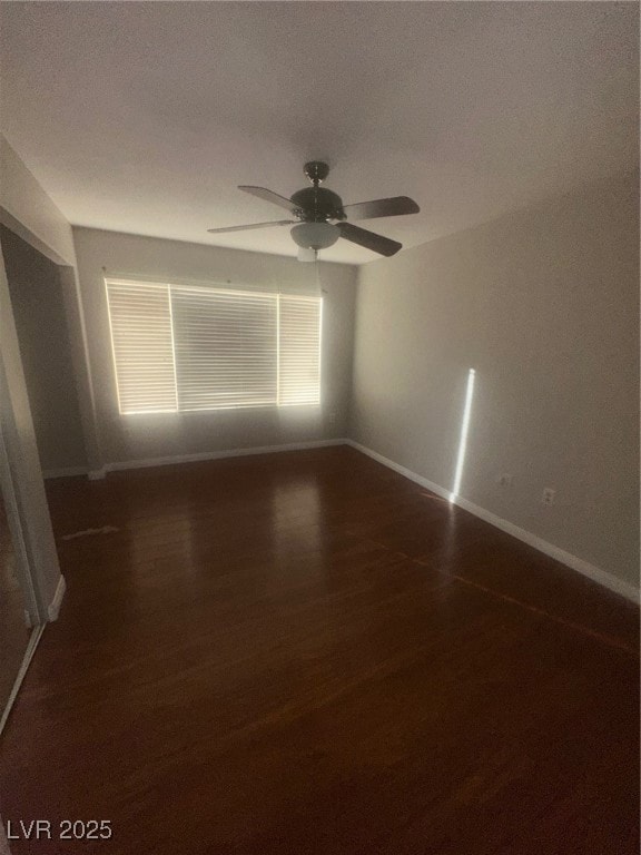 Empty room with dark wood finished floors, a textured ceiling, and a ceiling fan