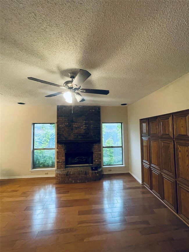 Unfurnished living room featuring ceiling fan, a b