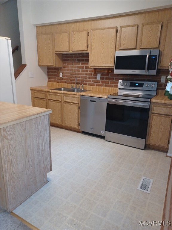 Kitchen with visible vents, range, light counterto