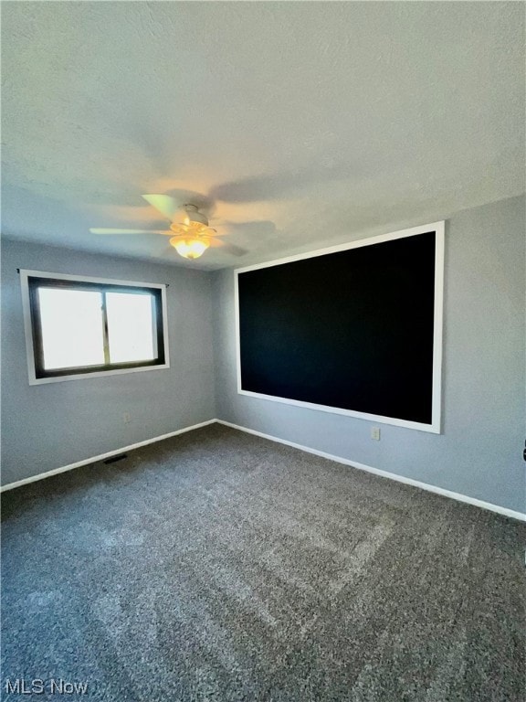 Carpeted spare room with ceiling fan and a textured ceiling
