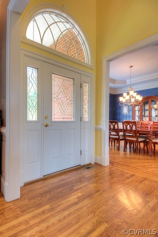 Two story foyer with hardwood floors and moldings