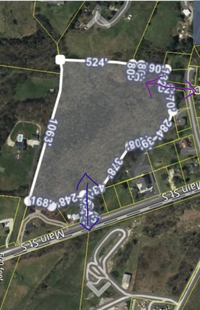 Blue arrow indicates entrance off Main Street.  Purple arrow indicates entrance off Sanders Drive.