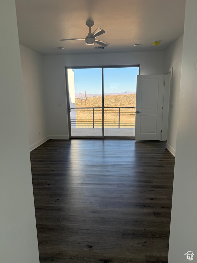 Unfurnished room with dark wood-style floors and a ceiling fan