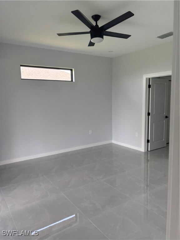 Spare room featuring ceiling fan and baseboards