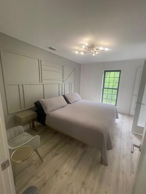 Bedroom with wood finished floors and baseboards