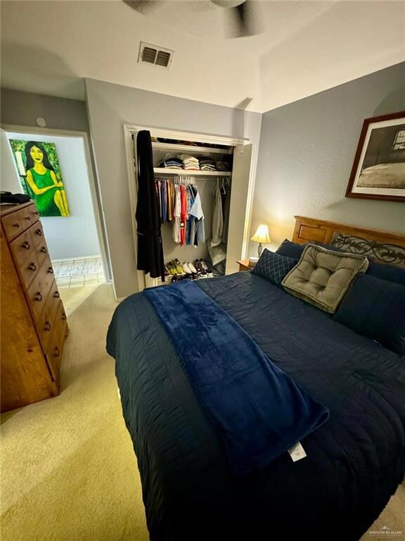 Carpeted bedroom with a closet and ceiling fan