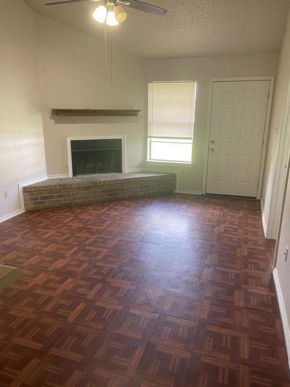 Unfurnished living room with ceiling fan and a br