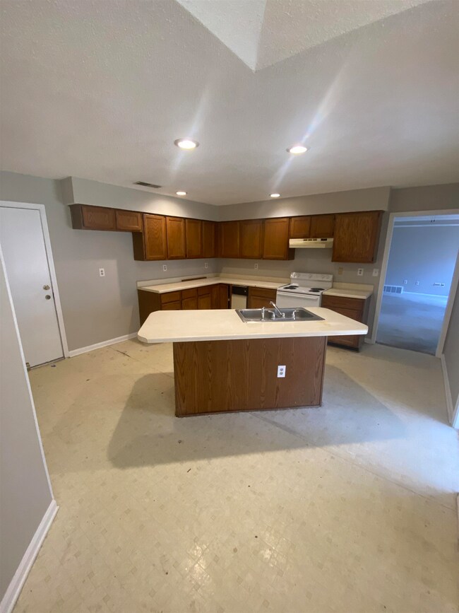 Kitchen featuring a kitchen island with sink, base