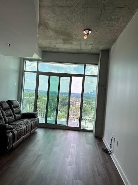 Living room featuring healthy amount of natural light, dark wood-style floors, and expansive windows