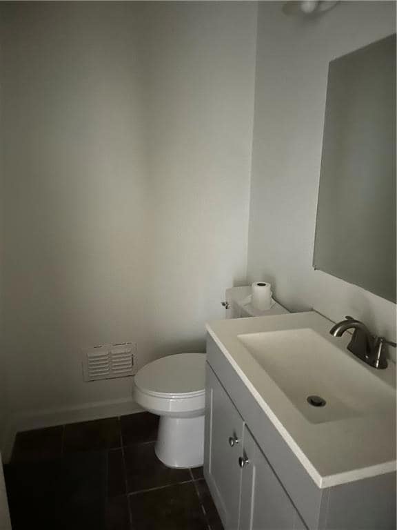 Bathroom with vanity, toilet, and tile patterned flooring