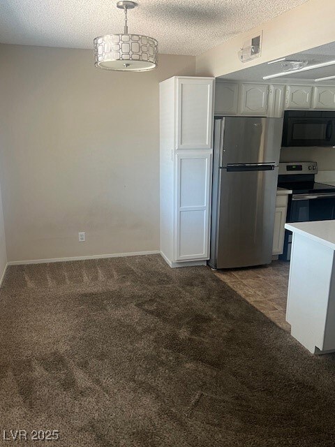 Kitchen featuring refrigerator, stove, carpet floo