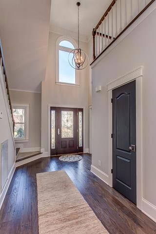 This expansive 2-story Foyer is perfect for welcoming visitors.  This view shows the second level palladium window, new Kichler-like Equinox light fixture & bold new flooring that extends throughout the main level...