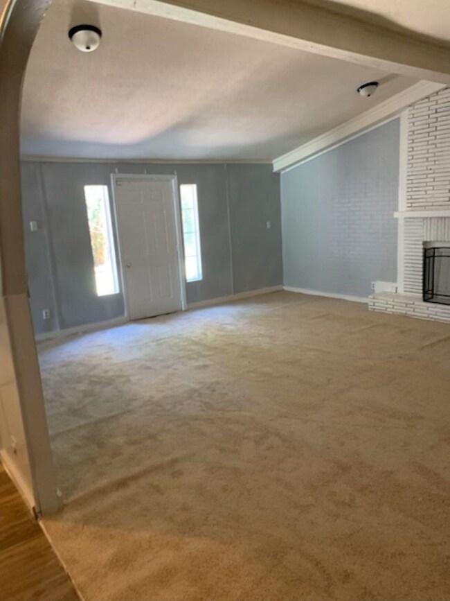 Unfurnished living room featuring crown molding, a