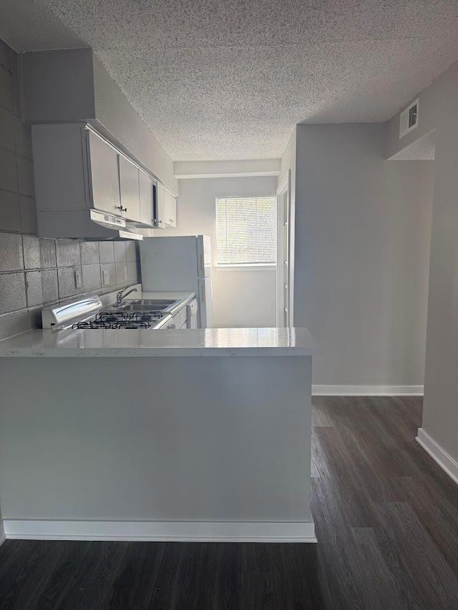 Kitchen featuring freestanding refrigerator, dark