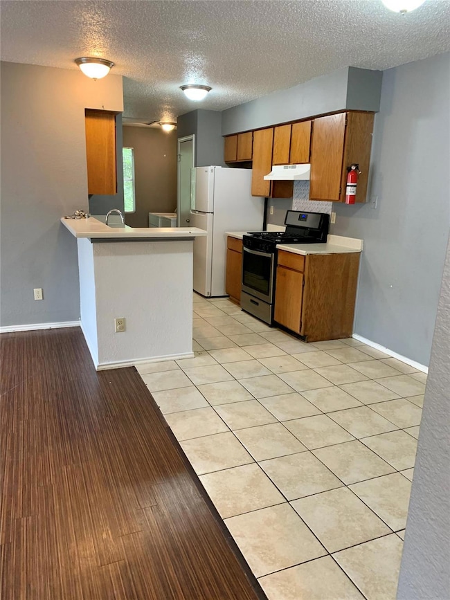 Kitchen featuring light countertops, gas stove, u