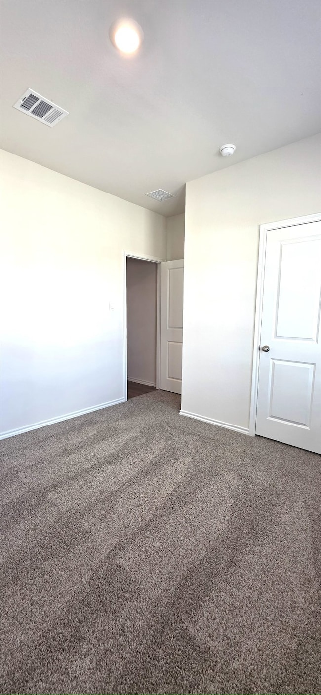 Unfurnished bedroom with baseboards and dark carpet