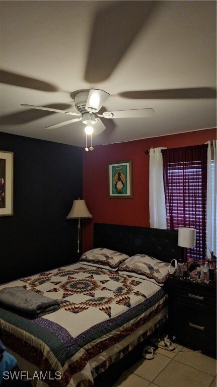 Tiled bedroom with a ceiling fan