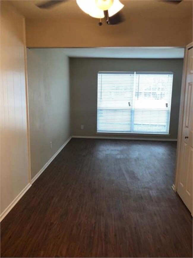 Empty room with ceiling fan and dark hardwood / wo