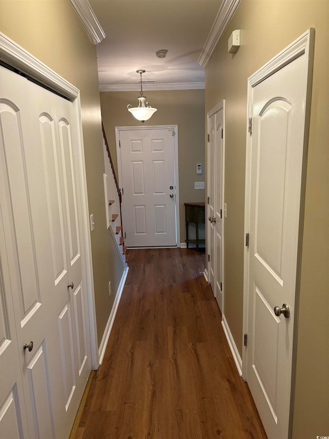 Doorway to outside with ornamental molding and dar
