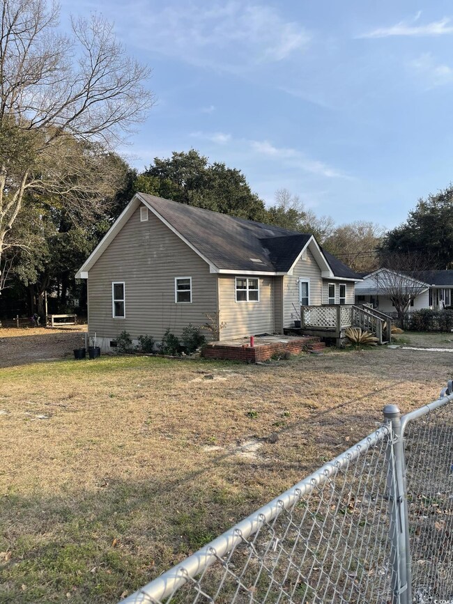 View of home's exterior with a wooden deck and a y