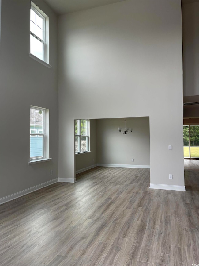 Unfurnished living room with a towering ceiling, l